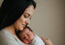 Newborn Care 101: Your Essential Guide to Thriving with a New Baby Parent cradling sleeping newborn baby.