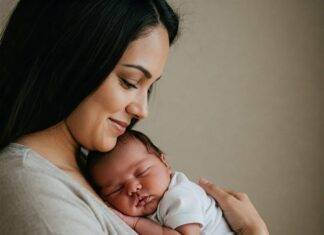 Newborn Care 101: Your Essential Guide to Thriving with a New Baby Parent cradling sleeping newborn baby.