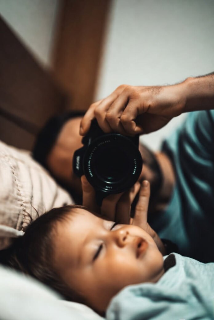 Slightly tilted view of a proud, messy-faced baby looking straight at dad. Slightly tilted view of a proud, messy-faced baby looking straight at dad.