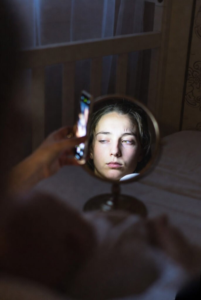 First nighttime swaddle, exhausted face in mirror