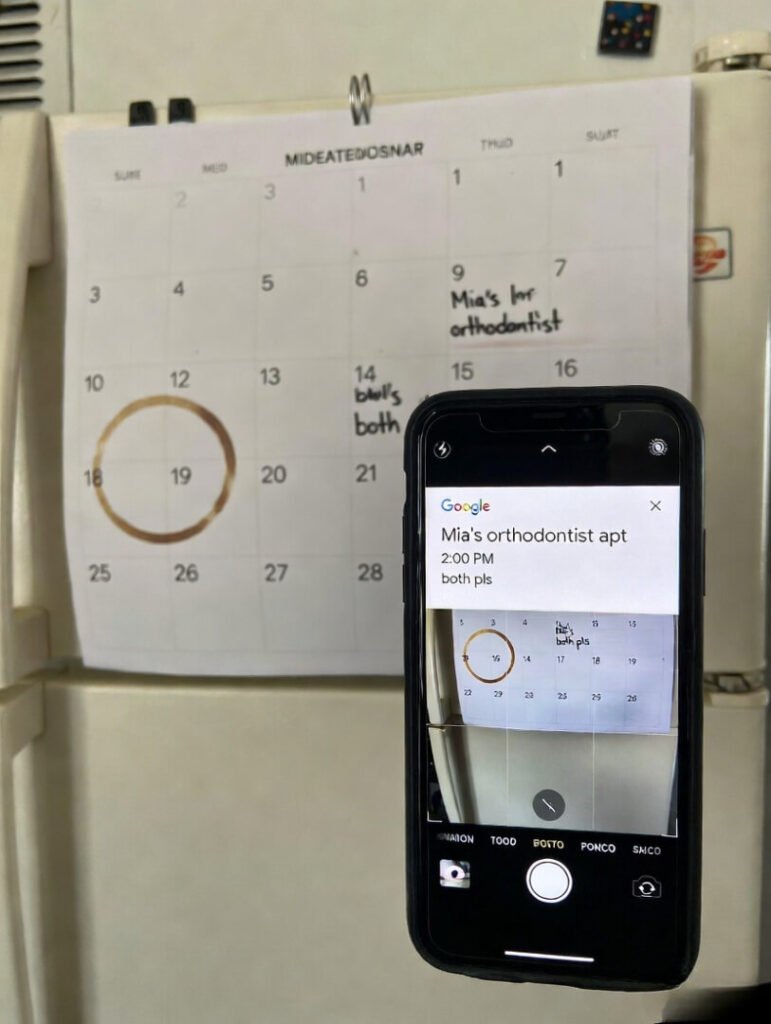 Slightly tilted annoyed snapshot: fridge calendar marked with coffee ring and “Mia’s orthodontist apt – both pls”, held up beside matching Google Calendar entry.