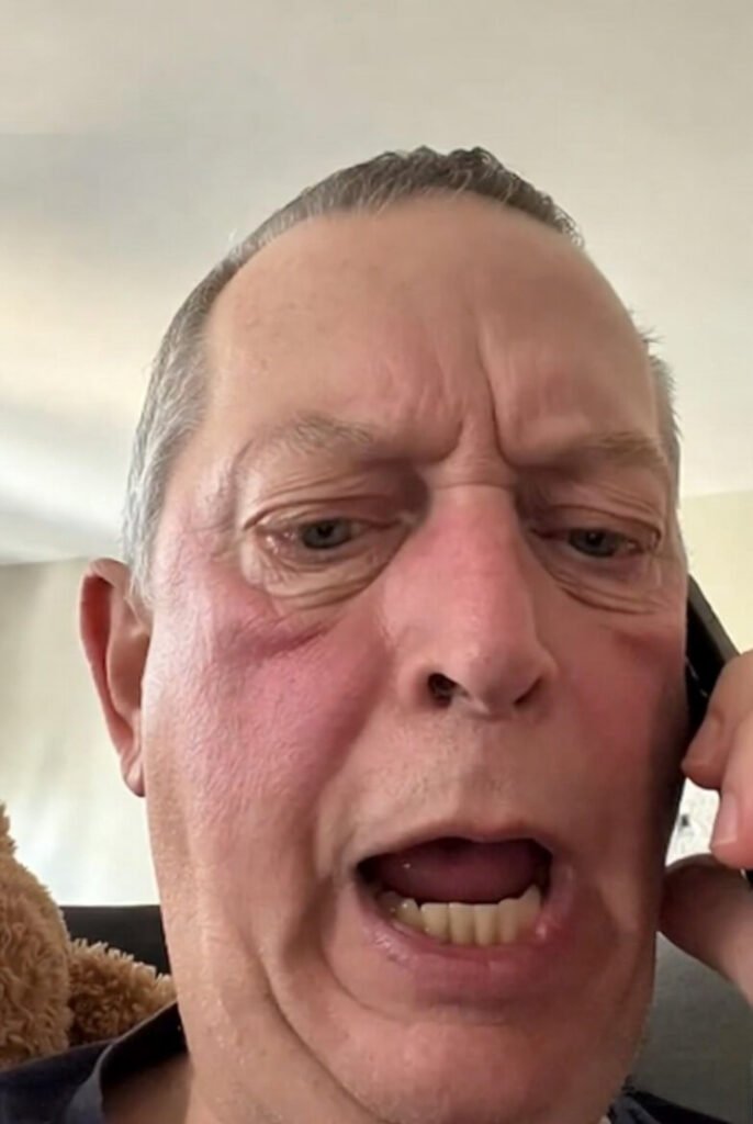 Close-up of elderly man looking puzzled on phone, shouting "wait wait" during chaotic grandkid call.