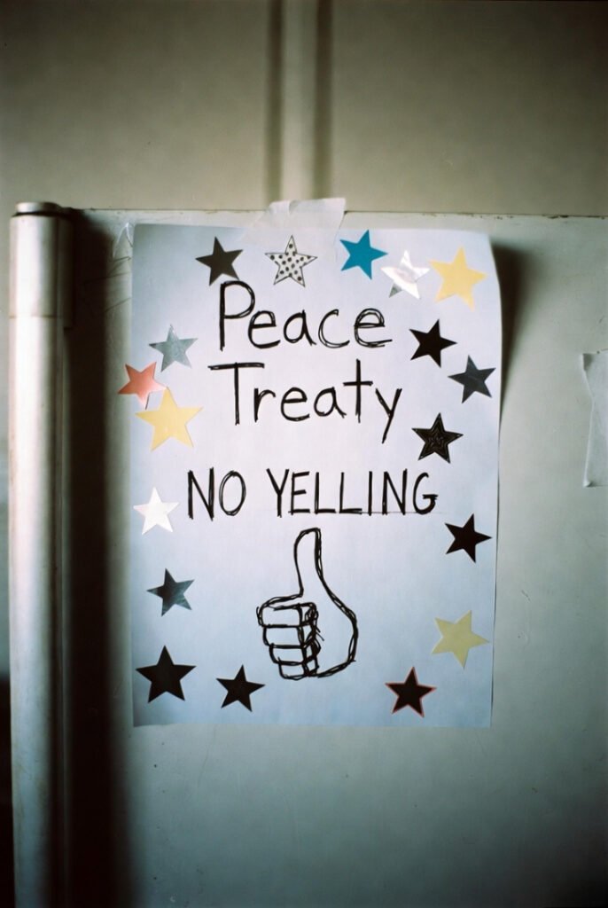 Curled “Peace Treaty” paper on fridge door, scattered mismatched stars, “NO YELLING” crossed out, strange thumbs-up sketch.