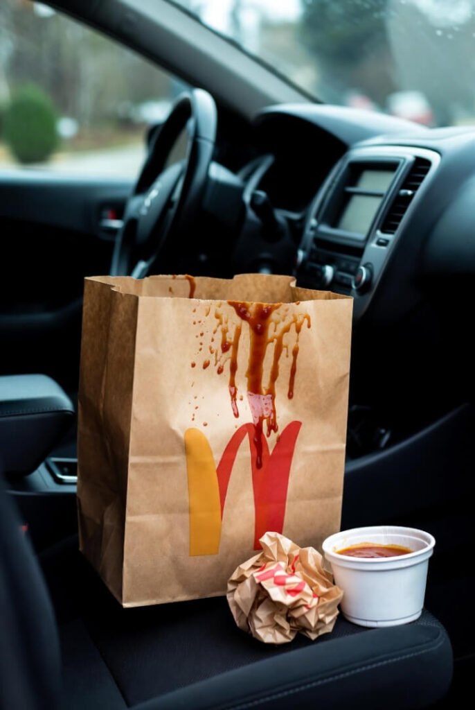 crumpled fast food bag with sauce stains dripping down, evidence of last night's guilty indulgence.